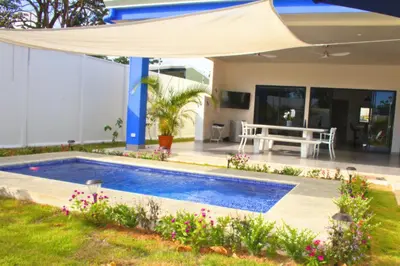 a swimming pool in the backyard of a house at Villa Libélula in Quepos