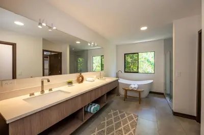 a large bathroom with a tub and a large mirror at Flamingo Oasis in Playa Flamingo