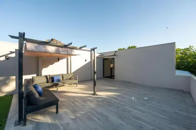 a patio with a couch and a white wall at Flamingo Oasis in Playa Flamingo