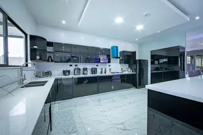 a large kitchen with black cabinets and a counter at Villa Montreal in Guayabal