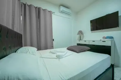 a bedroom with two beds and a television on the wall at Villa Montreal in Guayabal