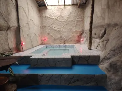a swimming pool in a cave with a stone wall at Vértice Blue Mountain Lodge la cueva de la montaña in San Lorenzo