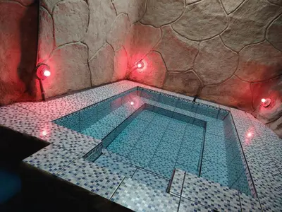 a swimming pool in a room with red lights at Vértice Blue Mountain Lodge la cueva de la montaña in San Lorenzo