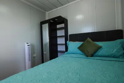 a bedroom with a bed with a blue comforter at Cabaña Los Lirios in Monteverde Costa Rica