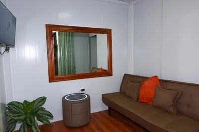 a living room with a couch and a mirror at Cabaña Los Lirios in Monteverde Costa Rica