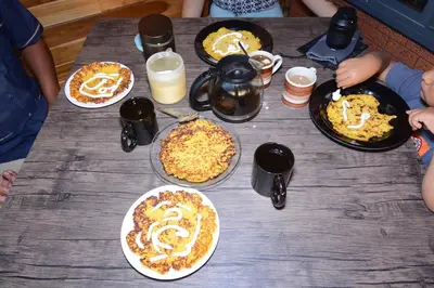 a wooden table with pizzas on plates on it at Cabaña Los Lirios in Monteverde Costa Rica