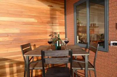 a dining room with a table with two glasses of wine at Cabaña Los Lirios in Monteverde Costa Rica