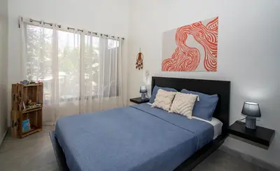 a bedroom with a blue bed and a painting on the wall at Uvita Tropical Bliss, Pool, Close to it all, 3bdrs in Uvita