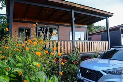 a car parked in front of a house with flowers at Cabaña Los Lirios 2 in Monteverde Costa Rica