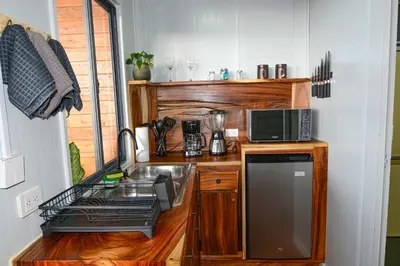 a small kitchen with a sink and a microwave at Cabaña Los Lirios 2 in Monteverde Costa Rica