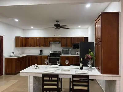 a kitchen with wooden cabinets and a white counter top at Apartamentos Santa Teresita in Santa Teresa Beach