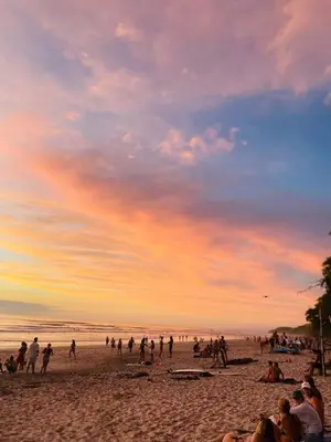 a group of people on a beach at sunset at Apartamentos Santa Teresita in Santa Teresa Beach