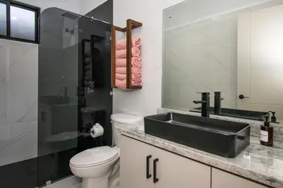 a bathroom with a black sink and a toilet at 5 min walk to Uvita beach, pool, 3 bdr, AC! in Uvita