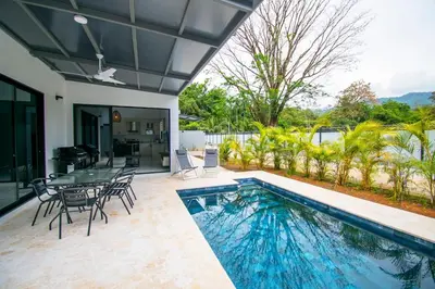 a patio with a pool and a table and chairs at 5 min walk to Uvita beach, pool, 3 bdr, AC! in Uvita