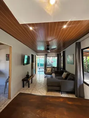 a living room with a couch and a tv at Casa Bahia Heliconia in Uvita