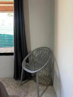 a white chair sitting in a corner next to a window at Casa Bahia Heliconia in Uvita