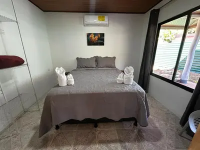 a bedroom with a bed with white shoes on it at Casa Bahia Heliconia in Uvita