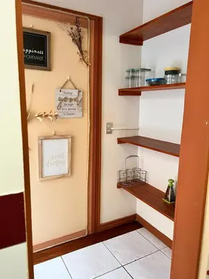 a kitchen with wooden shelves on the wall at Lotus apartment in San José