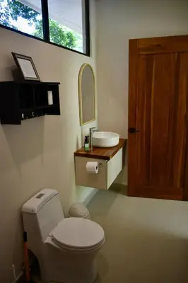 a bathroom with a toilet and a sink and a mirror at Casa Rio Tortuga - 2 Rooms in Tortugal