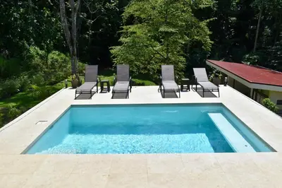 a swimming pool with chairs and a table at Casa Rio Tortuga - 2 Rooms in Tortugal