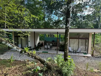 a house in the woods with a view of the living room at Casa Rio Tortuga - 2 Rooms in Tortugal