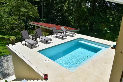 a swimming pool with chairs and a table on a patio at Casa Rio Tortuga - 2 Rooms in Tortugal
