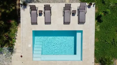 an overhead view of a swimming pool with chairs at Casa Rio Tortuga - 2 Rooms in Tortugal