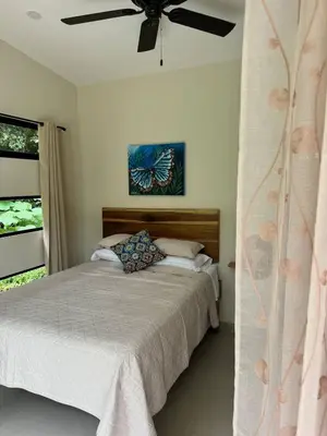 a bedroom with a bed and a ceiling fan at Casa Rio Tortuga - Butterfly in Ojochal