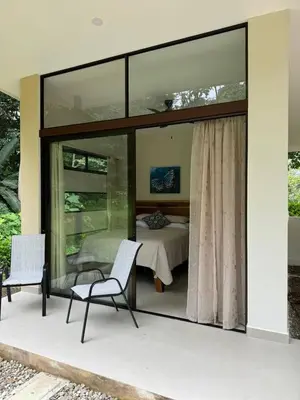 a glass house with a bedroom and a bed at Casa Rio Tortuga - Butterfly in Ojochal
