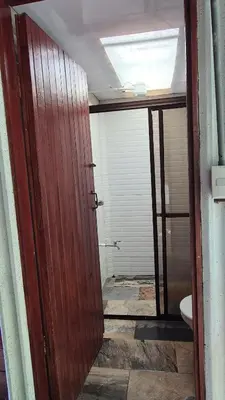 a wooden door to a bathroom with a toilet at Green Horizon in Upala
