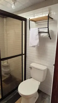 a bathroom with a toilet and a shower at Green Horizon in Upala