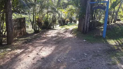 a dirt road with trees and a blue sign on it at Rincon Verde in Bijagua