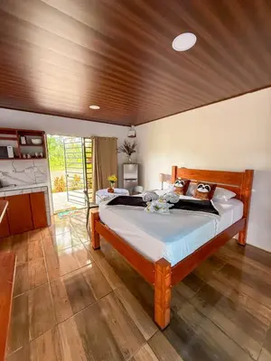 a bedroom with a large bed in a room at Refugio Las Cortezas in Fortuna