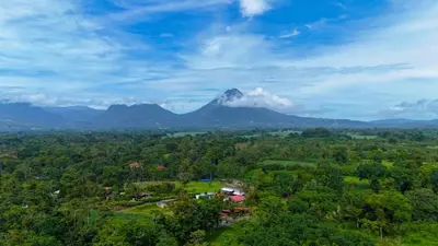 an aerial view of a mountain with a village and trees at Refugio Las Cortezas in Fortuna