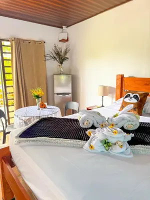 a bedroom with two beds and two tables at Refugio Las Cortezas in Fortuna