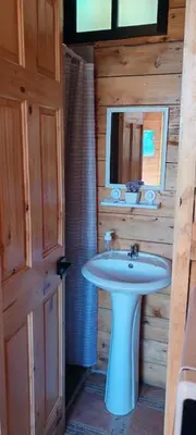 a bathroom with a white sink and a mirror at Cabañas La Madriguera