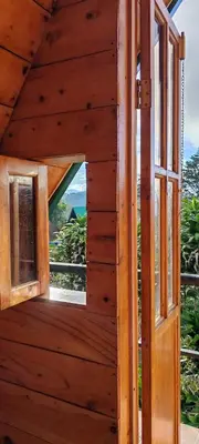 an open window in a wooden house with a view at Cabañas La Madriguera