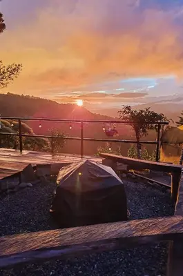 a tent on the ground with the sunset in the background at Cabañas La Madriguera