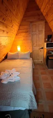 a bedroom with a bed in a wooden cabin at Cabañas La Madriguera
