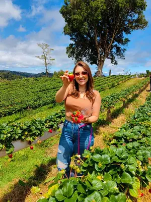 a woman standing in a field holding a carrot at Cerro Lodge & Gardens in Cartago