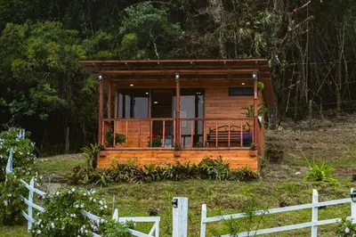 a small cabin in a field with a fence at Cerro Lodge & Gardens in Cartago