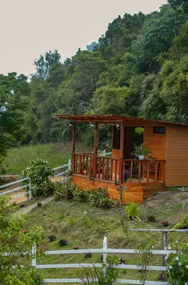 a wooden cabin in the middle of a field at Cerro Lodge & Gardens in Cartago