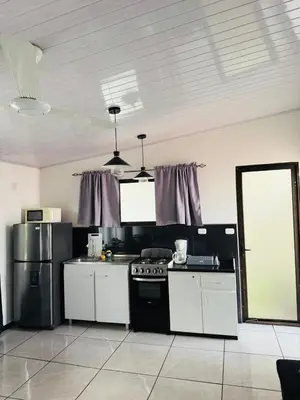 a kitchen with white cabinets and a black stove at Casa Mia in Sámara
