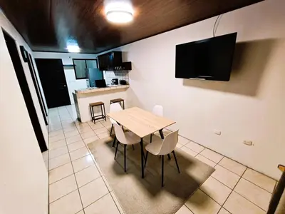 a kitchen and dining room with a wooden table and chairs at Apartment JESALU, just 3 minutes from the Airport in San Antonio