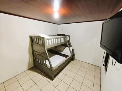 a small room with two bunk beds and a tv at Apartment JESALU, just 3 minutes from the Airport in San Antonio