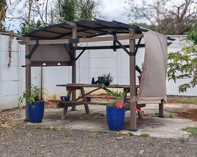 a wooden picnic table with a canopy and a bench at Apartment JESALU, just 3 minutes from the Airport in San Antonio