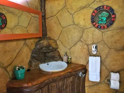 a bathroom with a sink and a stone wall at Villa Tucan in Agua Azul