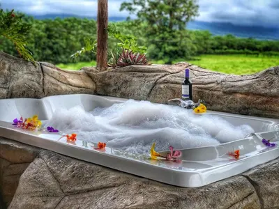 a bath tub with a sink with flowers in it at Villa Tucan in Agua Azul