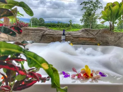a bath tub filled with foam and a bottle of wine at Villa Tucan in Agua Azul