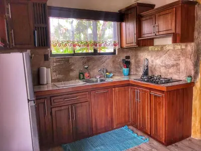 a kitchen with wooden cabinets and a sink and a refrigerator at Villa Tucan in Agua Azul
